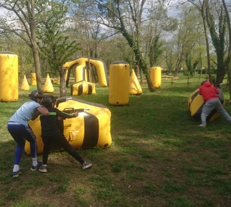 Photo du terrain de laser game en plein nature : de nombreux obstacles et modules gonflables jaunes sont disposés.
